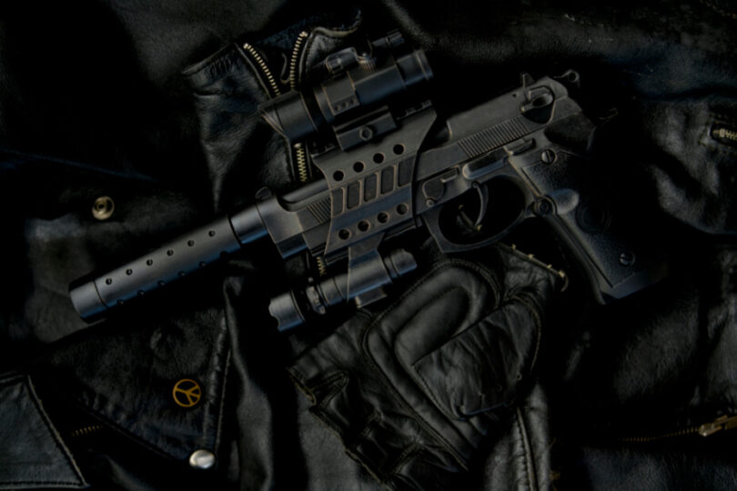image of a handgun with a supressor, scope and light mount